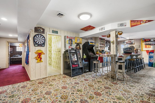 interior space featuring visible vents, wooden walls, and carpet floors