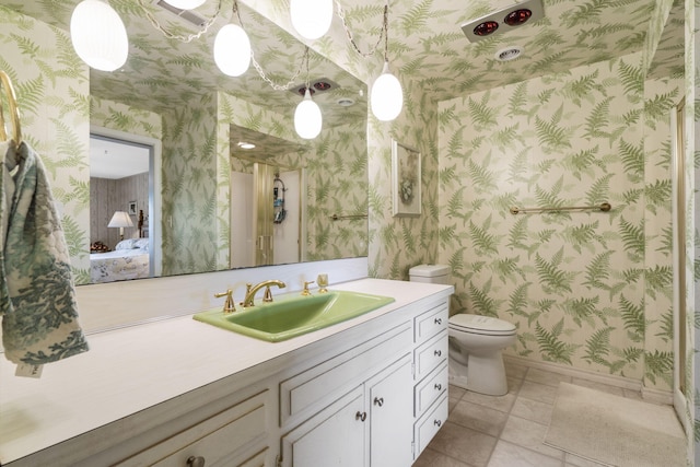 bathroom with wallpapered walls, baseboards, toilet, vanity, and tile patterned flooring