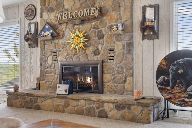 interior details featuring wooden walls, carpet, and a fireplace