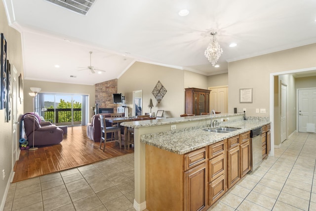 kitchen with stainless steel dishwasher, a sink, visible vents, a peninsula, and light tile patterned flooring