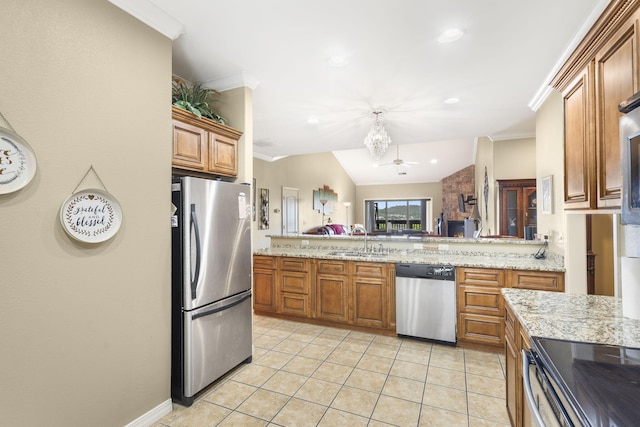 kitchen with an inviting chandelier, brown cabinetry, appliances with stainless steel finishes, a sink, and crown molding