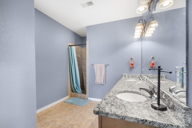 bathroom featuring an inviting chandelier, visible vents, a tile shower, and a sink