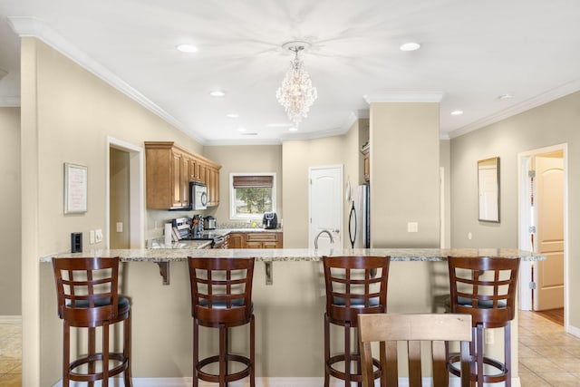kitchen featuring appliances with stainless steel finishes, light stone counters, a peninsula, and recessed lighting