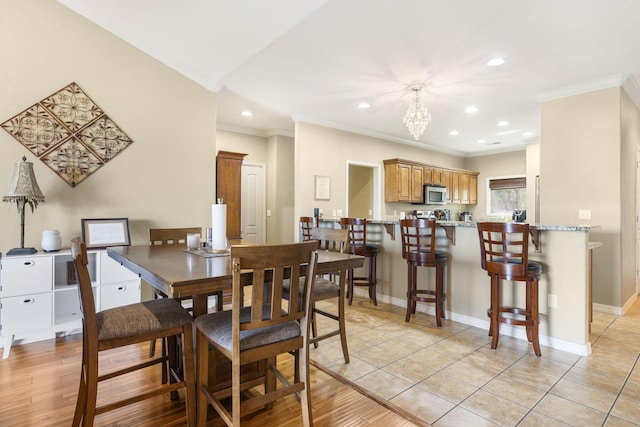 dining space with recessed lighting, an inviting chandelier, ornamental molding, baseboards, and light tile patterned flooring