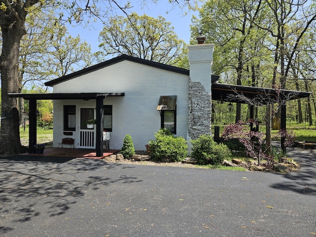 view of side of home featuring a chimney and brick siding