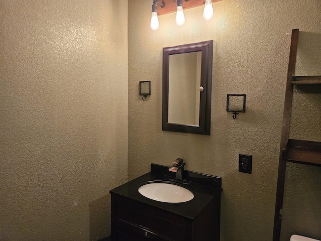 bathroom featuring a textured wall and vanity