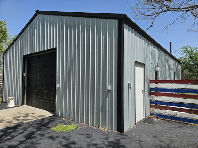 detached garage featuring fence