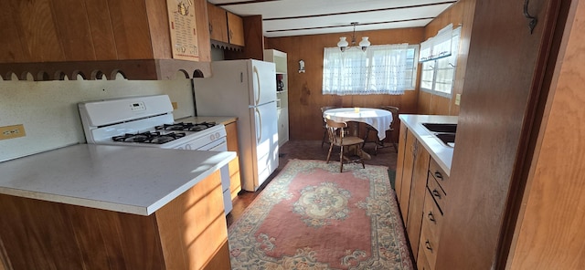 22684 Forest Ln, Hermitage, MO 65668 - kitchen with white appliances, a chandelier, brown cabinetry, light countertops, and wood walls