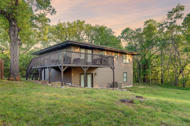 9247 State Highway 13, Kimberling City, MO 65686 - back of property at dusk featuring a lawn, a wooden deck, and central AC unit