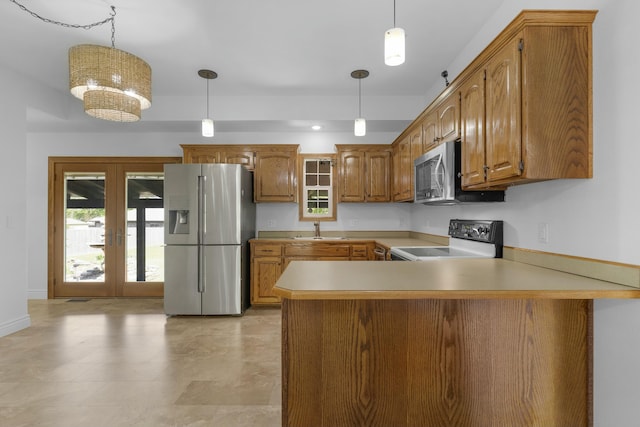 kitchen with a sink, brown cabinetry, french doors, stainless steel appliances, and a peninsula