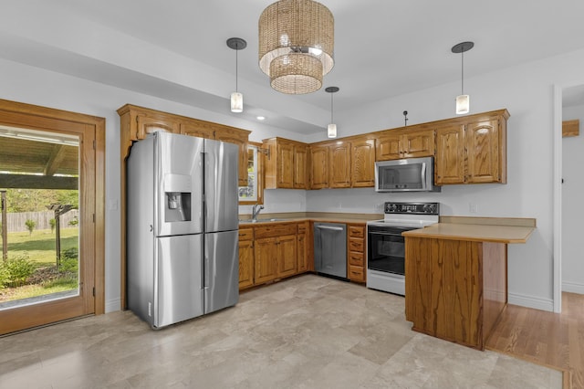kitchen featuring a sink, light countertops, brown cabinetry, and stainless steel appliances