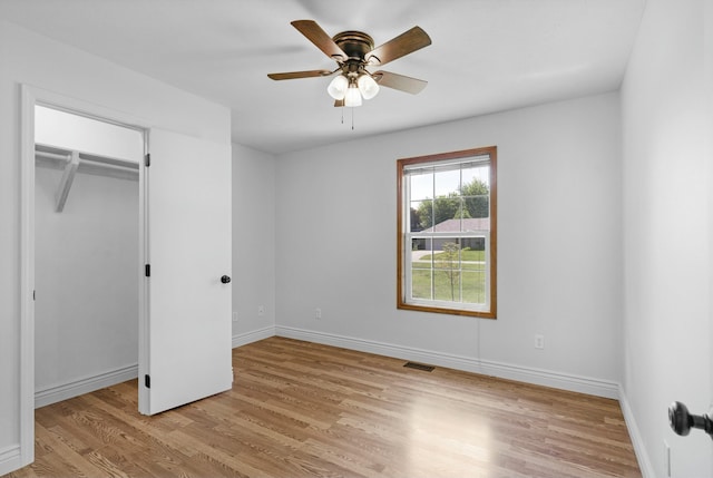 unfurnished bedroom with light wood-style floors, a ceiling fan, baseboards, visible vents, and a closet