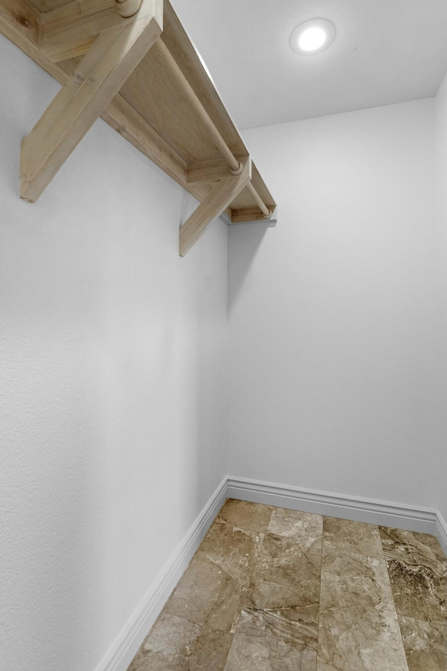 walk in closet with stone finish flooring