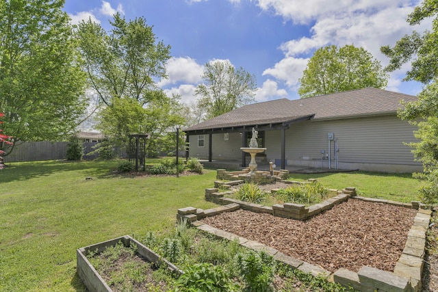 view of yard featuring fence and a garden