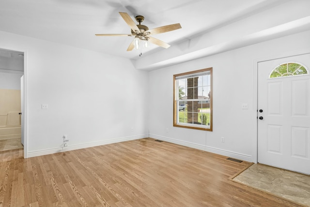 entryway featuring baseboards, ceiling fan, light wood-type flooring, and visible vents