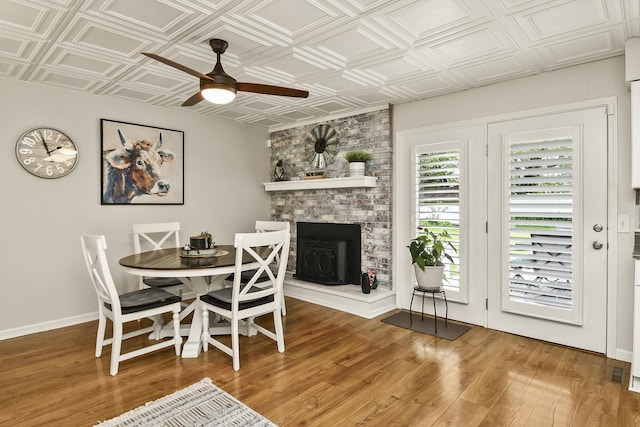 1522 S Oakland Ave, Bolivar, MO 65613 - dining room featuring an ornate ceiling, ceiling fan, a fireplace, and wood finished floors