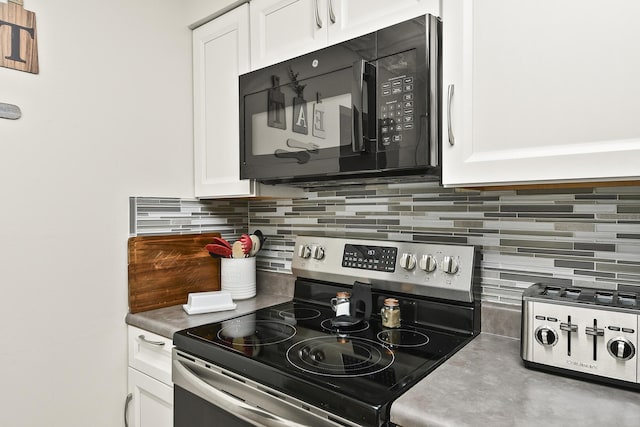 1522 S Oakland Ave, Bolivar, MO 65613 - kitchen with white cabinetry, black microwave, decorative backsplash, and stainless steel range with electric stovetop