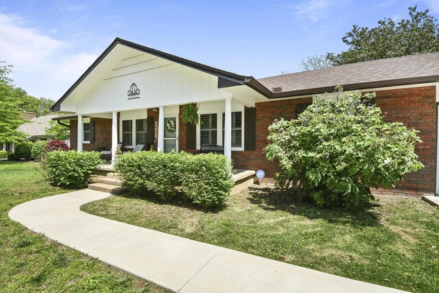 1522 S Oakland Ave, Bolivar, MO 65613 - view of front of property featuring covered porch, brick siding, and a front lawn