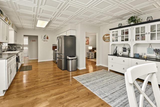 1522 S Oakland Ave, Bolivar, MO 65613 - kitchen featuring washer / clothes dryer, an ornate ceiling, white cabinets, a sink, and stainless steel appliances