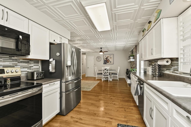 1522 S Oakland Ave, Bolivar, MO 65613 - kitchen featuring appliances with stainless steel finishes, an ornate ceiling, a ceiling fan, white cabinetry, and tasteful backsplash