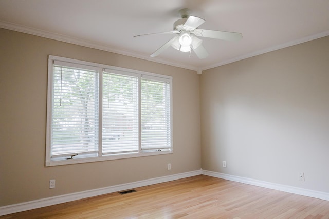 spare room with ornamental molding, light wood finished floors, ceiling fan, and visible vents
