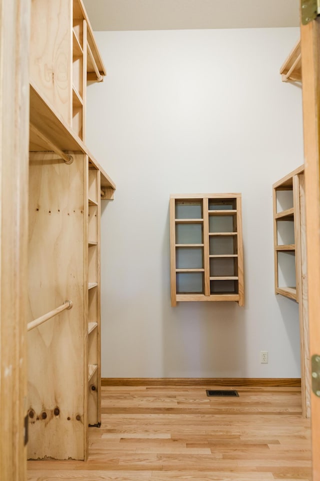 walk in closet with wood finished floors and visible vents