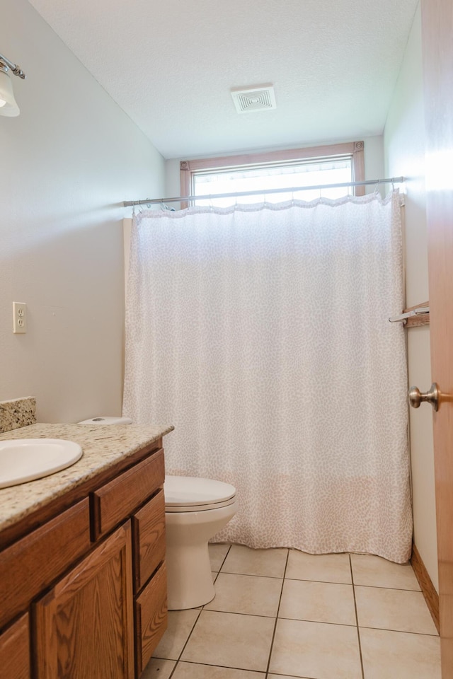 bathroom with tile patterned floors, vanity, toilet, and visible vents