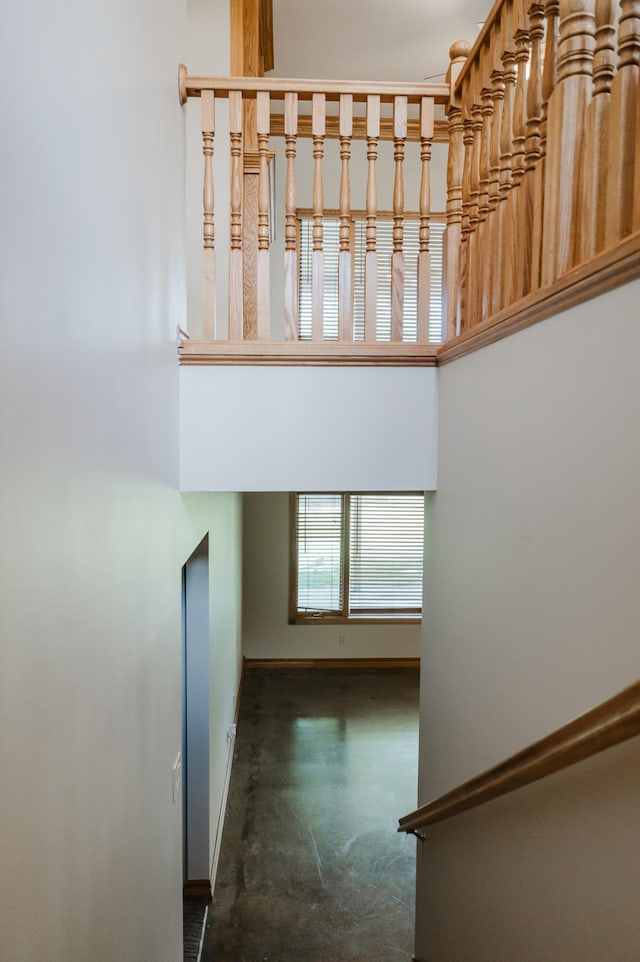 staircase with baseboards and concrete flooring