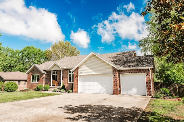ranch-style home with brick siding, fence, an attached garage, and driveway