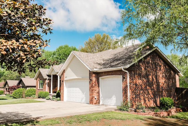 view of front of house with brick siding, a shingled roof, an attached garage, and driveway
