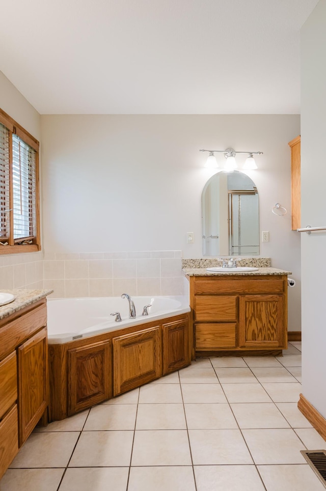 bathroom with a sink, tile patterned floors, two vanities, visible vents, and a garden tub