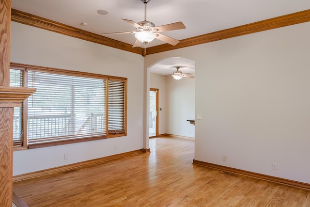empty room featuring plenty of natural light, a ceiling fan, light wood-style floors, and ornamental molding