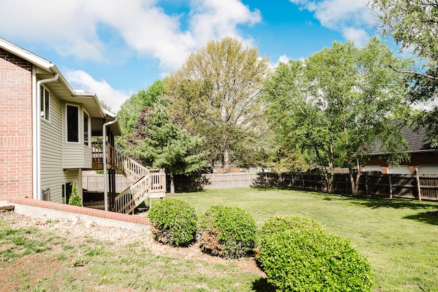 view of yard with a fenced backyard and stairway
