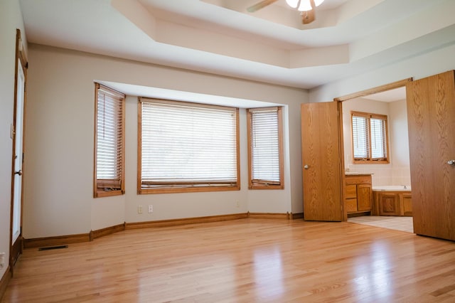 unfurnished bedroom with connected bathroom and light wood-style flooring