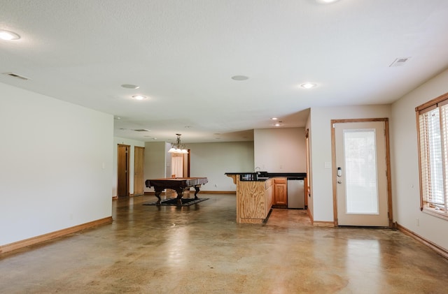 kitchen with dark countertops, baseboards, and concrete floors