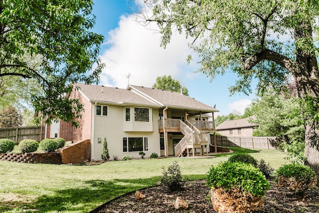 back of property with a yard, stairs, and a fenced backyard
