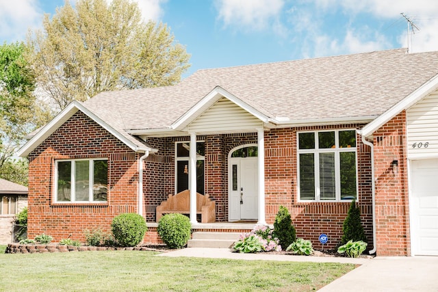 ranch-style house featuring driveway, a front yard, roof with shingles, a garage, and brick siding