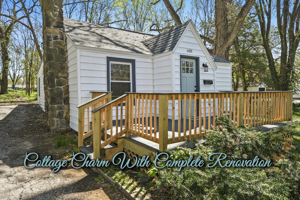 exterior space with a shingled roof and a wooden deck