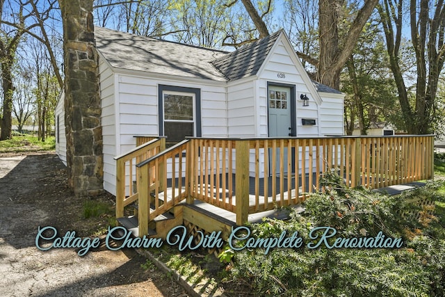 exterior space with a shingled roof and a wooden deck