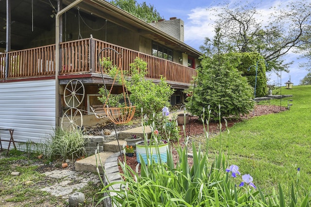 exterior space with a wooden deck, a yard, and a chimney