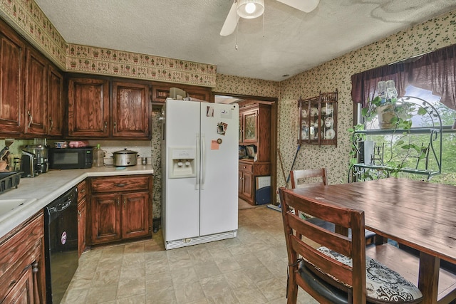 kitchen featuring light countertops, black appliances, wallpapered walls, and a textured ceiling