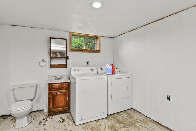 clothes washing area featuring independent washer and dryer, laundry area, and a sink