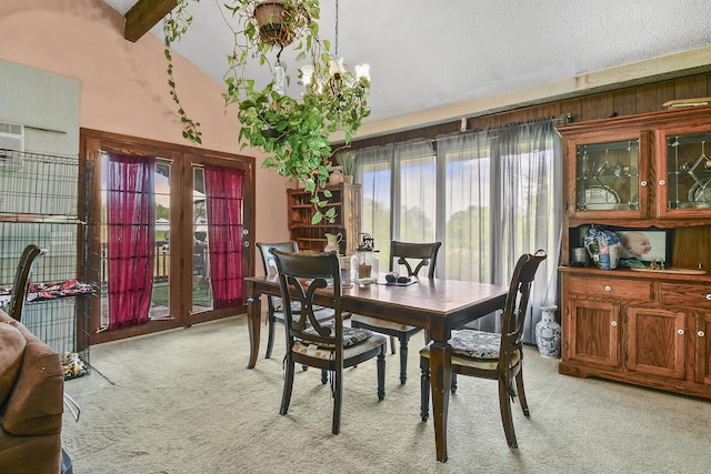 dining space with a textured ceiling, vaulted ceiling, light carpet, and plenty of natural light