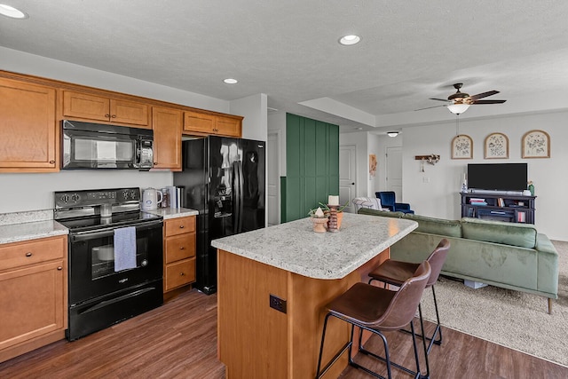1418 S Lorraine Ave, Republic, MO 65738 - kitchen with a breakfast bar, a center island, open floor plan, dark wood-style floors, and black appliances