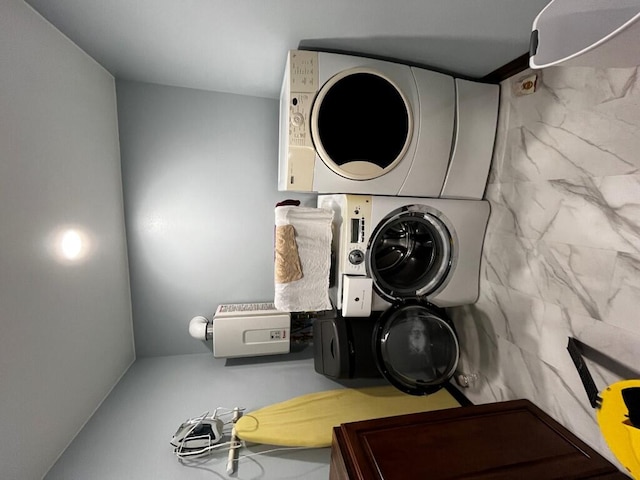 washroom with laundry area and stacked washing maching and dryer