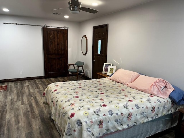 bedroom featuring visible vents, a barn door, wood finished floors, and recessed lighting