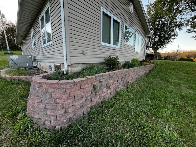 view of side of home featuring a lawn and cooling unit