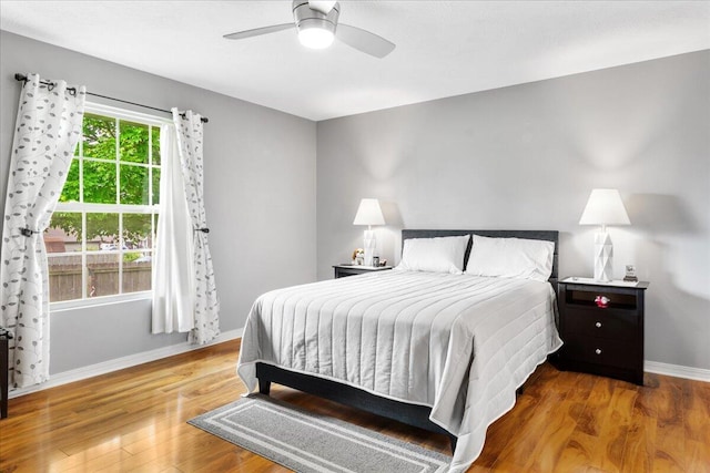 bedroom with baseboards, a ceiling fan, and wood finished floors