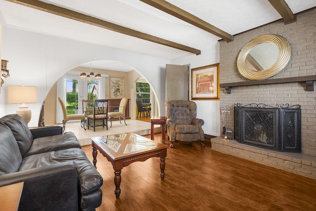 3660 S Ferguson Ave, Springfield, MO 65807 - living room featuring wood finished floors, a fireplace, beamed ceiling, a chandelier, and arched walkways
