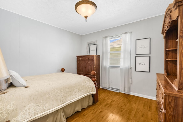 3660 S Ferguson Ave, Springfield, MO 65807 - bedroom featuring baseboards, ornamental molding, light wood-style flooring, and a textured ceiling